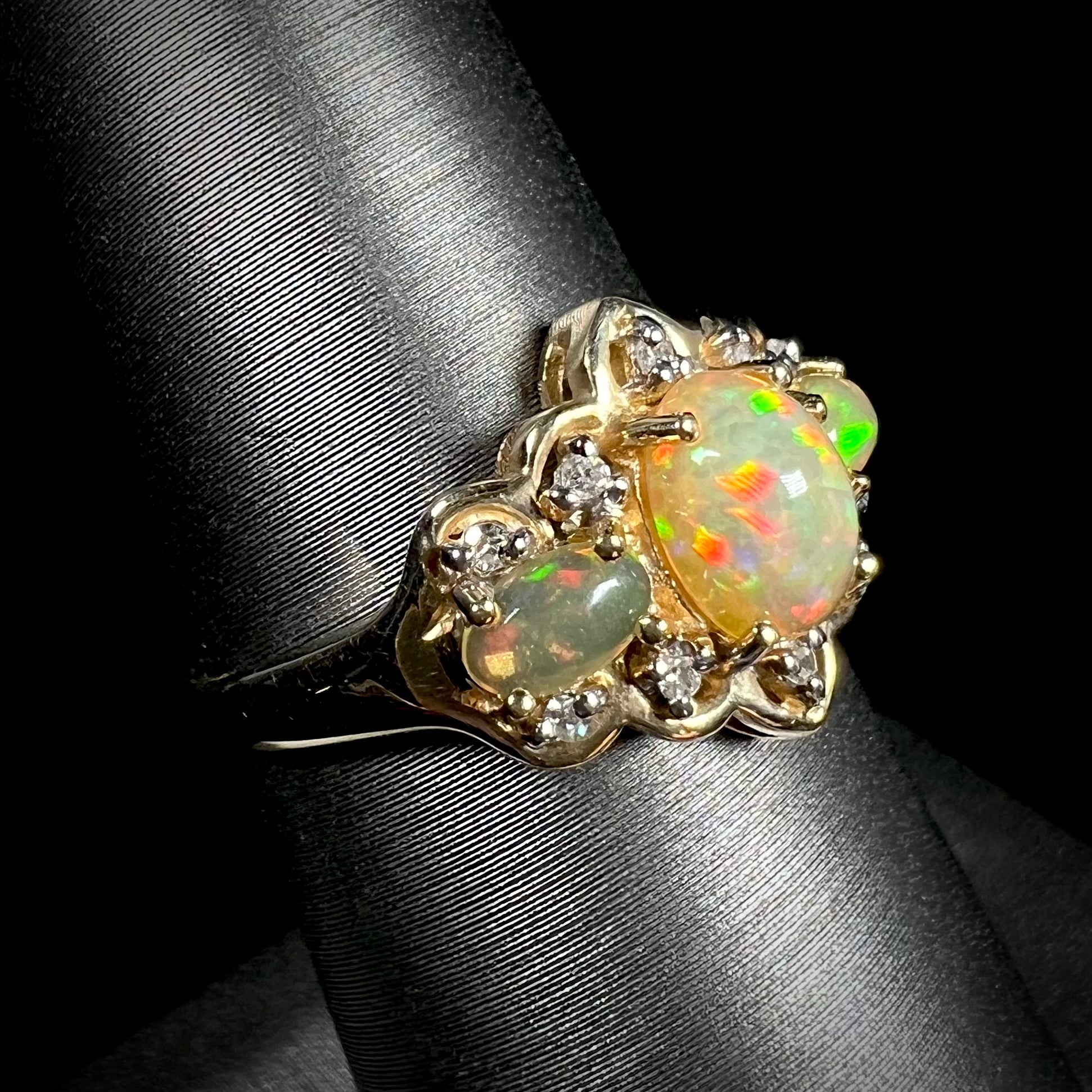 A three-stone gold ring set with Ethiopian fire opals and diamond accents.