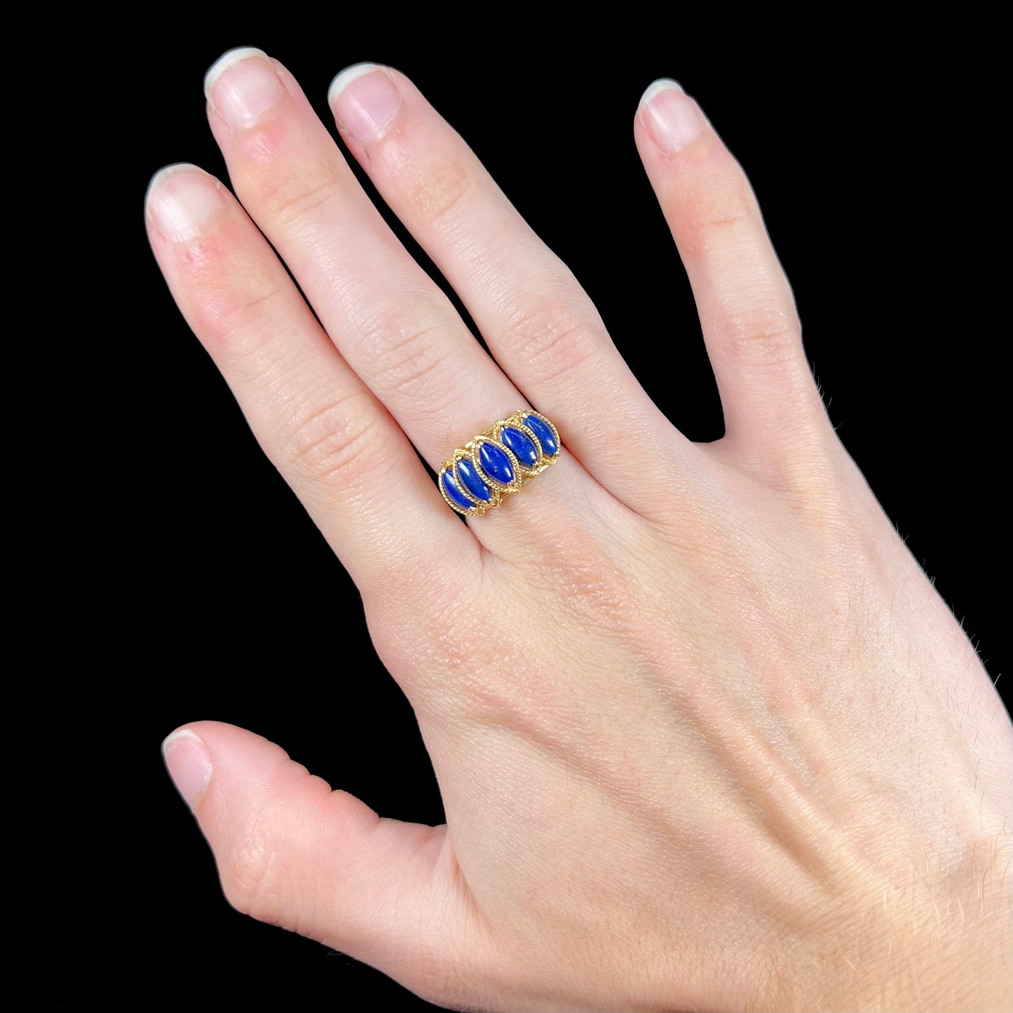 A ladies' five stone marquise cabochon cut lapis lazuli ring in yellow gold.