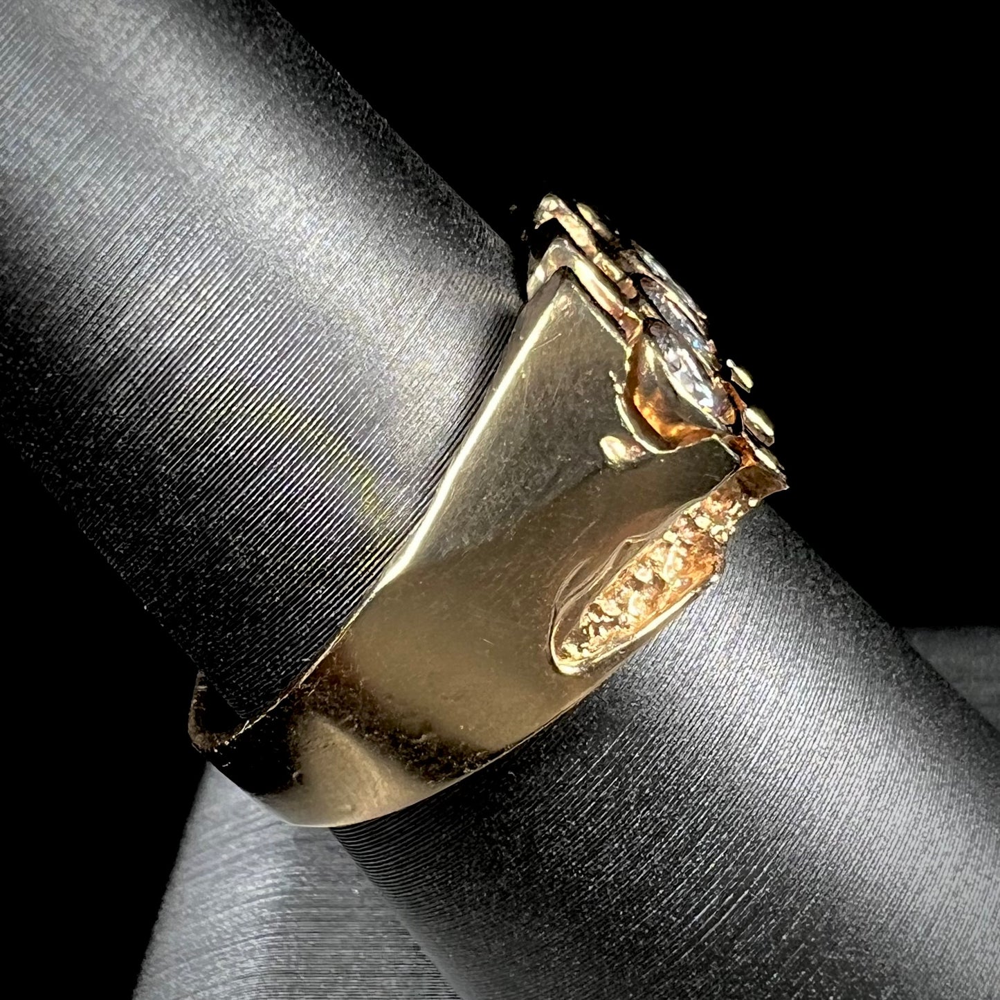 A men's yellow gold ring set with three round brilliant cut diamonds.  There are scratches along the shank.