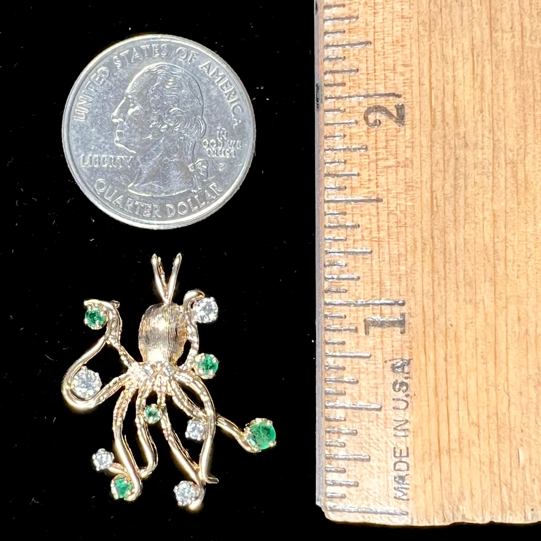 A yellow gold octopus pendant set with round cut emeralds and diamonds in the tentacles.