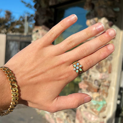 A vintage, 1950's style opal cluster ring cast in yellow gold with a heart shaped filigree design.