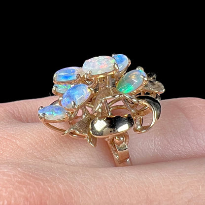 A ladies' vintage, modernist style opal cluster ring in yellow gold.  The ring is tall with a high profile.