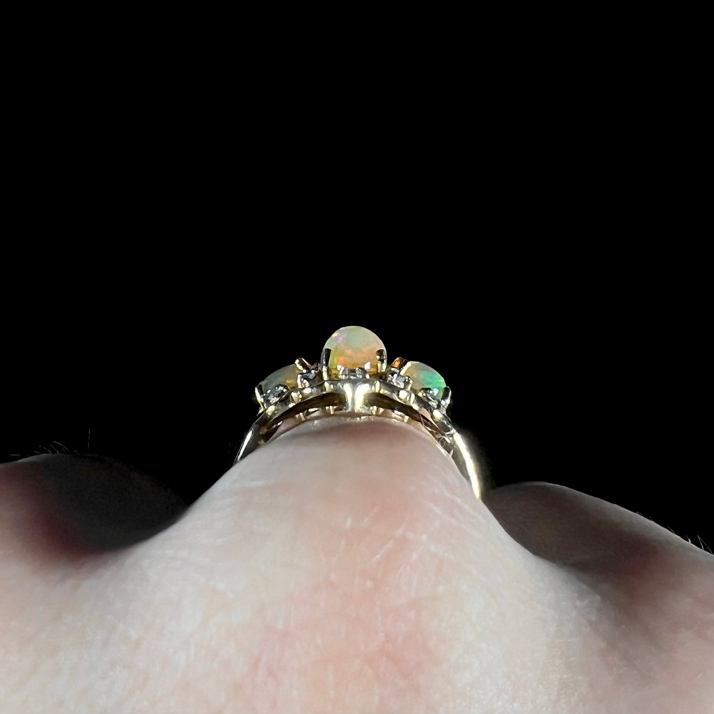 A three-stone gold ring set with Ethiopian fire opals and diamond accents.