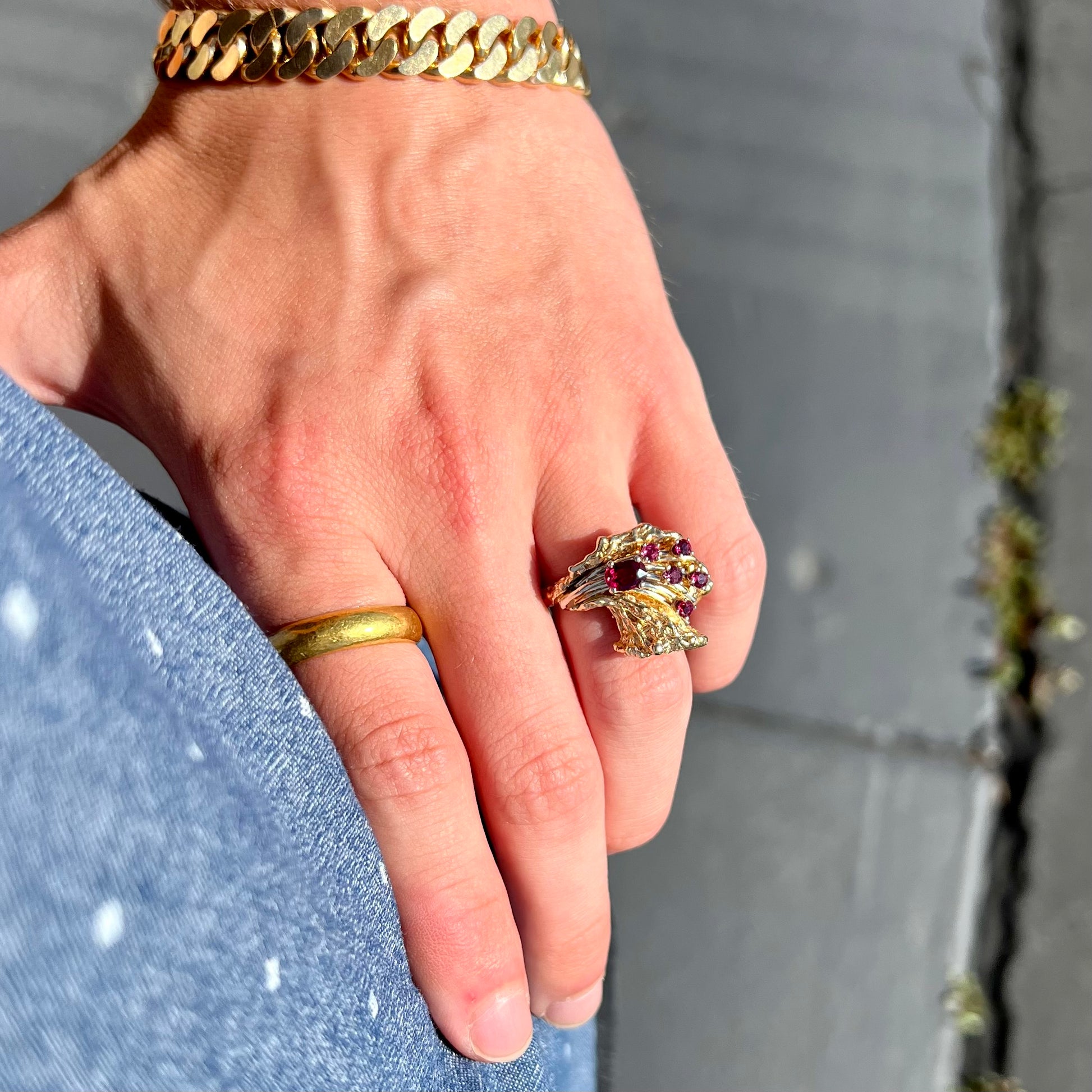 A yellow gold ruby cluster ring from the 1950's.  There is one oval cut ruby and five round cut rubies.