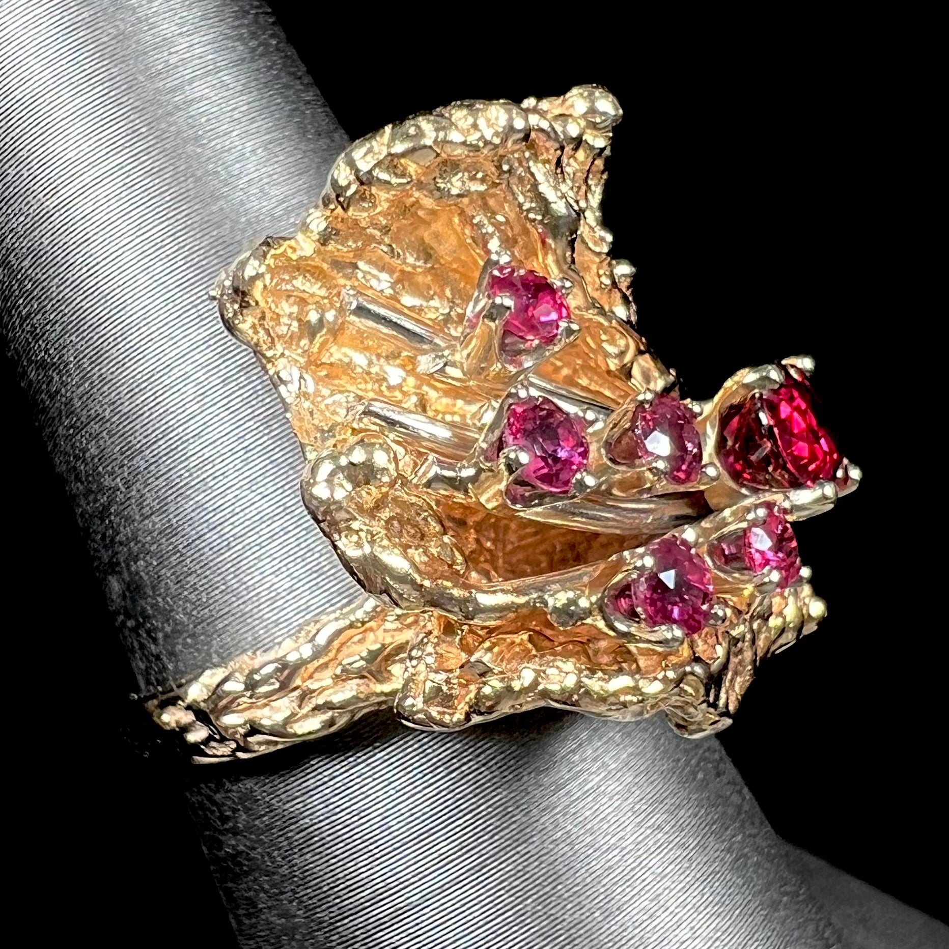 A yellow gold ruby cluster ring from the 1950's.  There is one oval cut ruby and five round cut rubies.