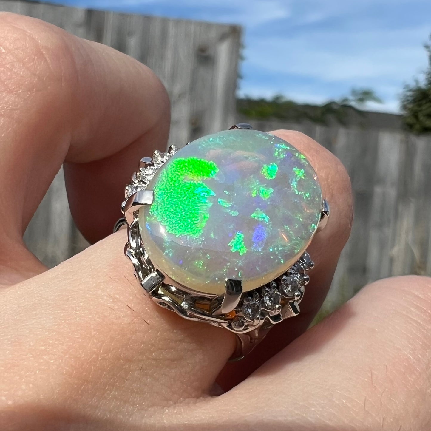 A platinum filigree engagement ring set with a large, green-blue Australian crystal opal.