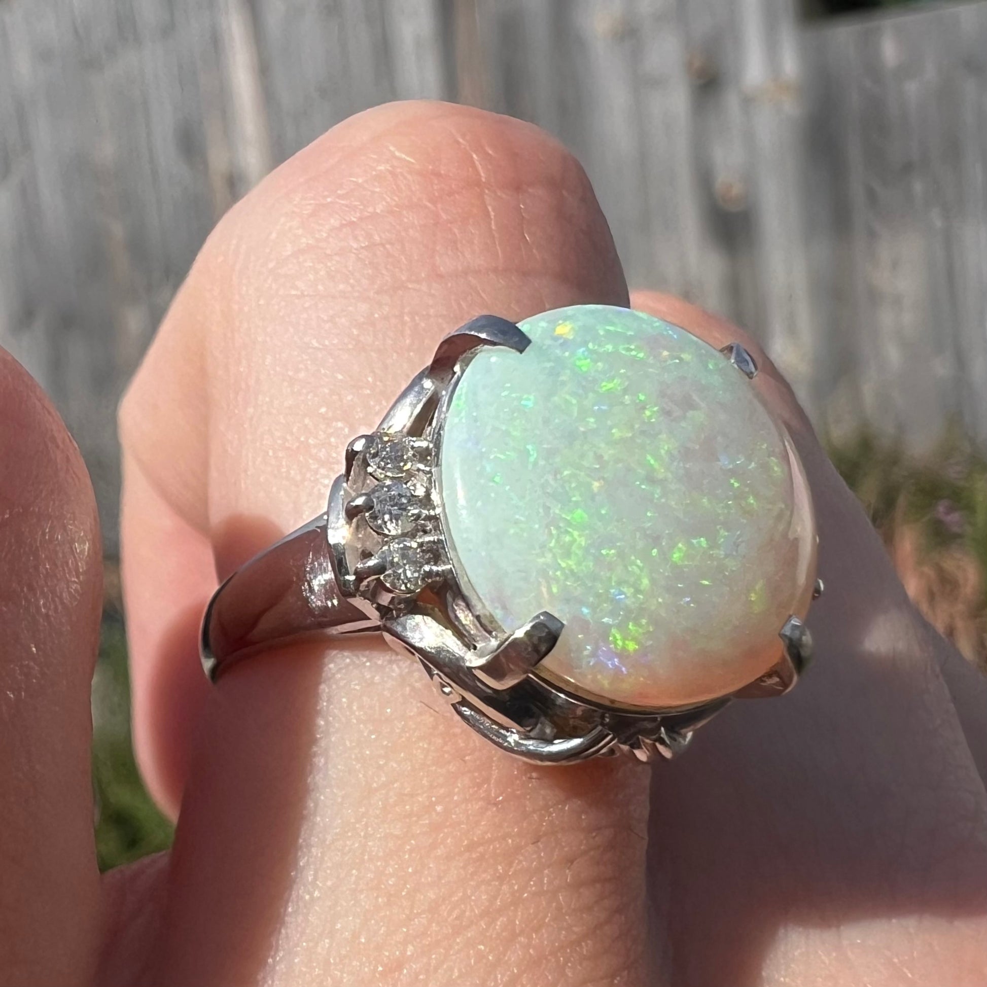 A round cut Australian opal and diamond engagment ring with platinum filigree.