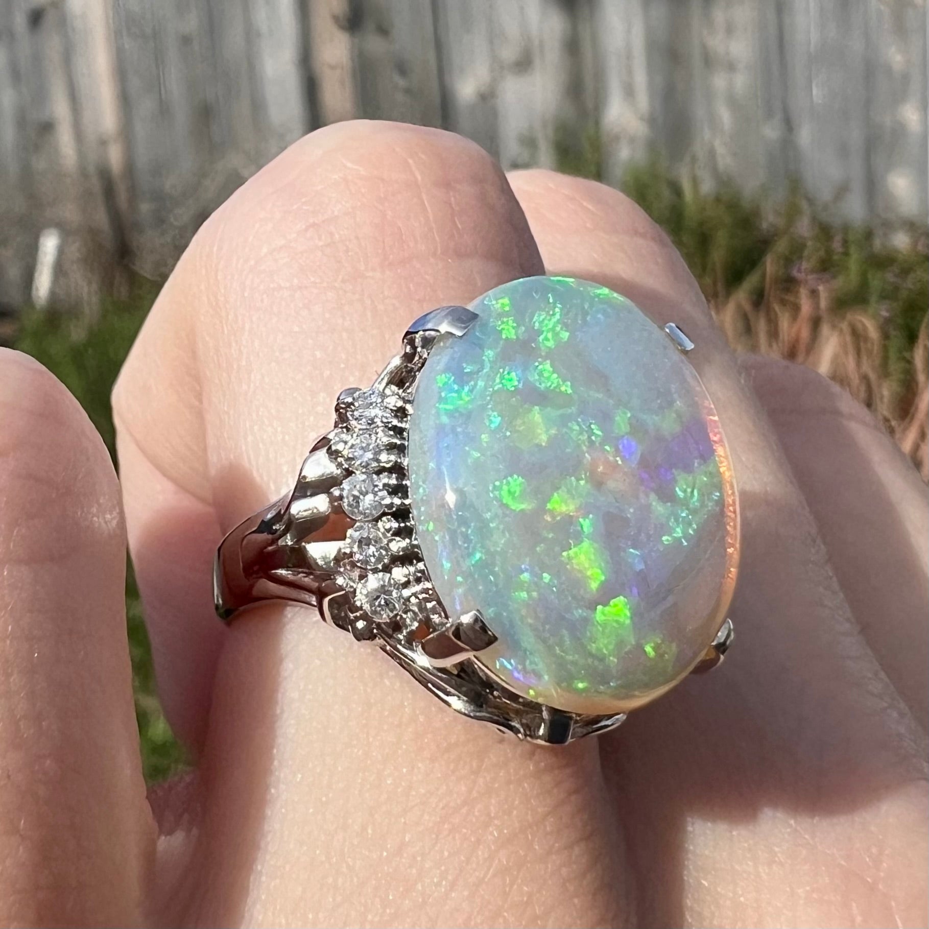 A platinum filigree engagement ring set with a large, green-blue Australian crystal opal.