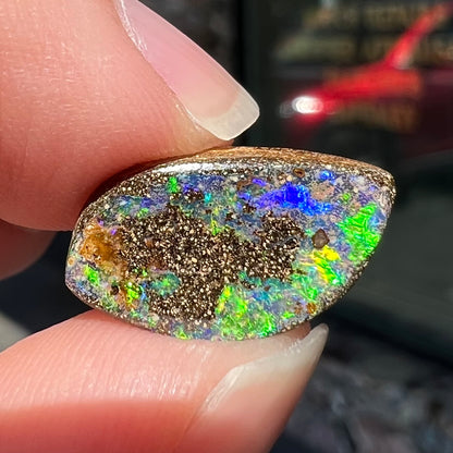 A loose boulder opal stone from Quilpie, Australia.  The opal has bright green and blue flashes.