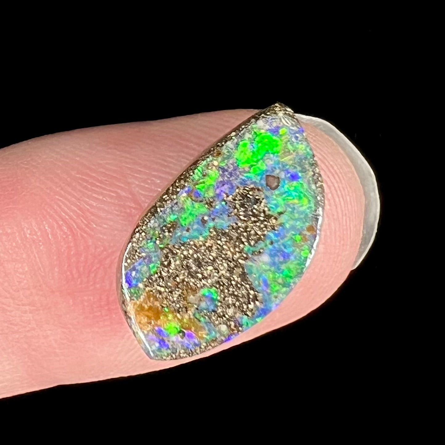 A loose boulder opal stone from Quilpie, Australia.  The opal has bright green and blue flashes.