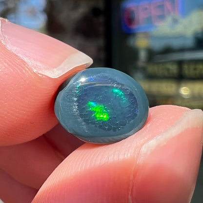 A 2.68 carat loose, oval cabochon cut black opal stone from Lightning Ridge, Australia.  The opal has a N2 body tone.