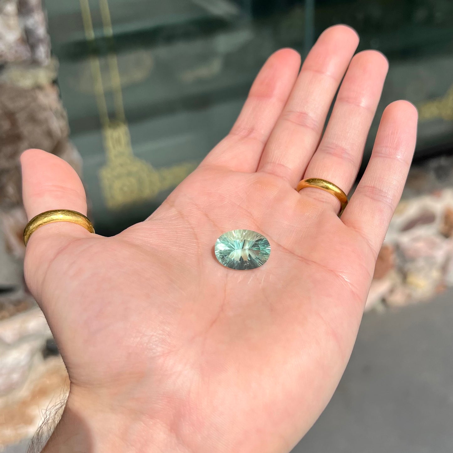 A loose, faceted oval cut mint green fluorite gemstone.