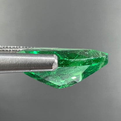 A loose, pear shaped tsavorite garnet gemstone.  The stone is vivid green color.