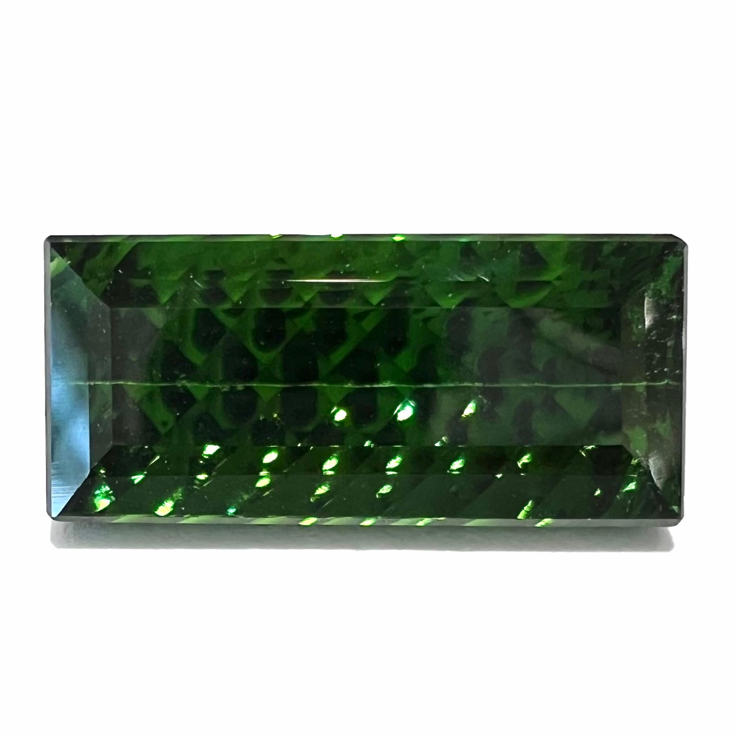 A loose, rectangular laser cut green tourmaline gemstone.