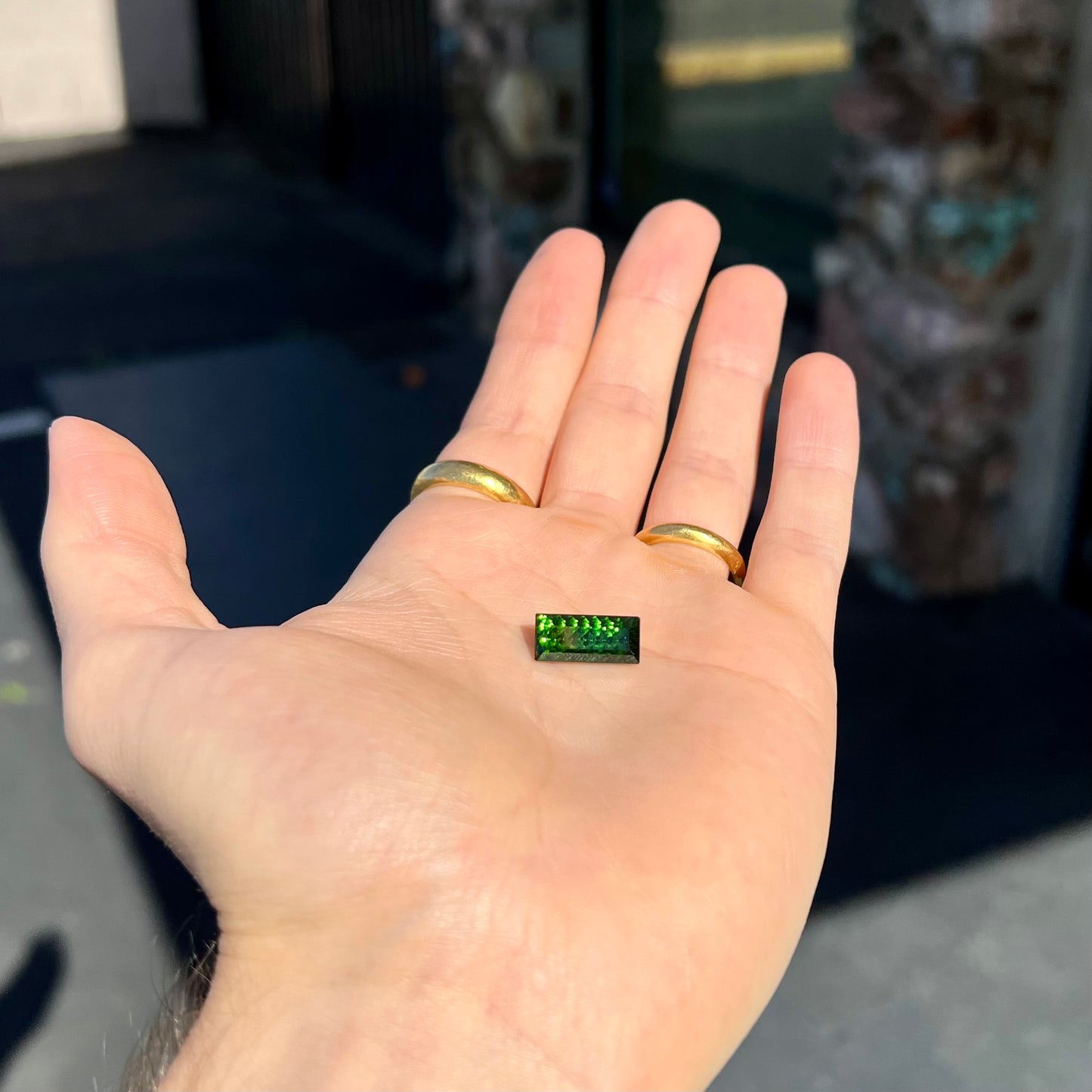 A loose, rectangular laser cut green tourmaline gemstone.