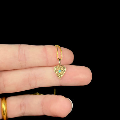 A yellow gold filigree heart necklace set with a round Australian crystal opal.  The opal has green fire.