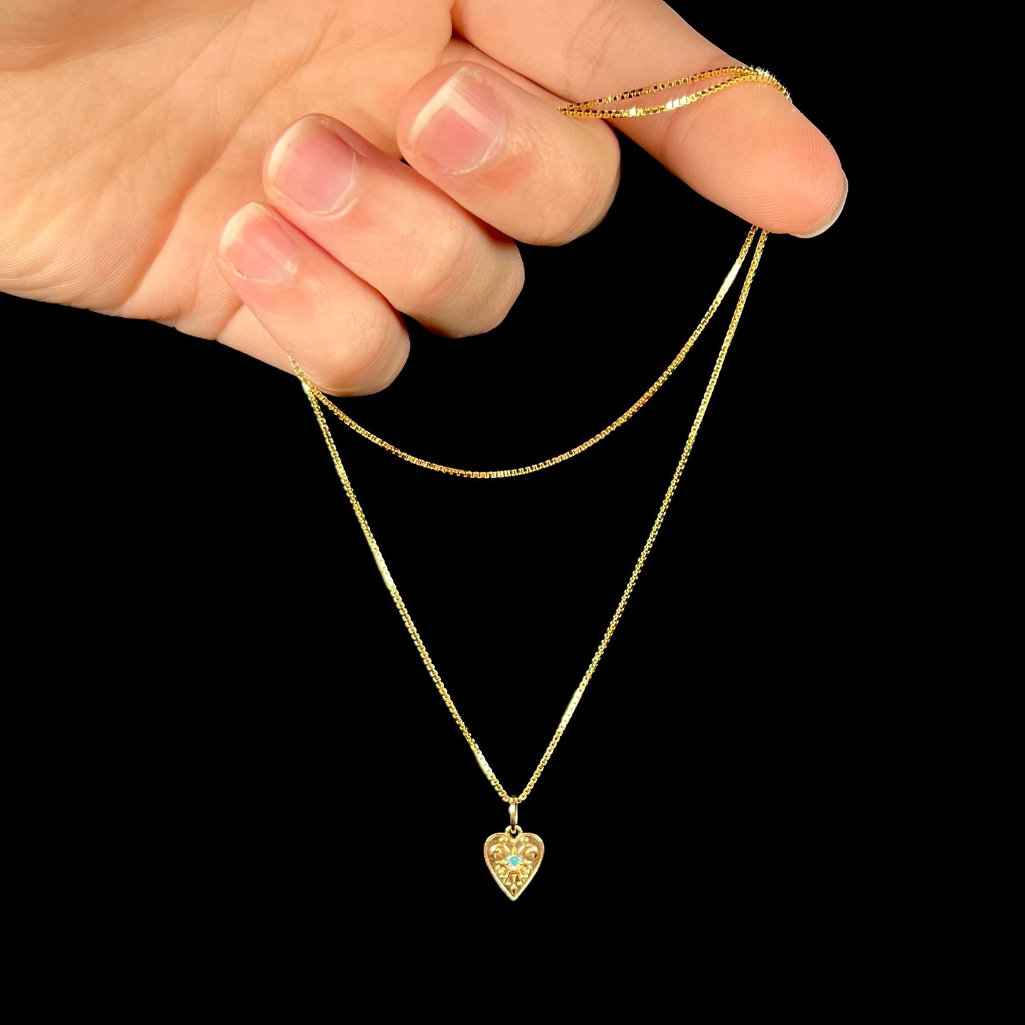 A yellow gold filigree heart necklace set with a round Australian crystal opal.  The opal has green fire.