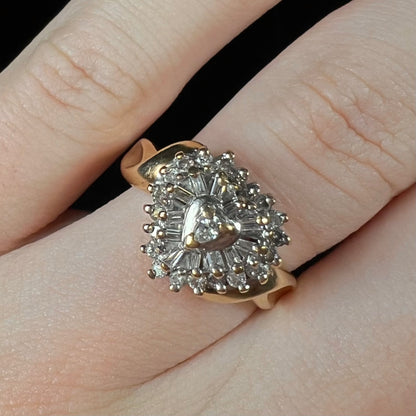 A ladies' heart shaped diamond cluster ring.  The ring is set with pear shaped, baguette cut, and round diamonds.