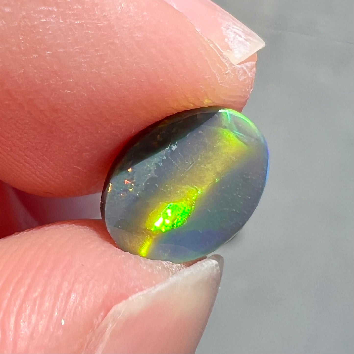 A loose, oval cut black opal from Lighting Ridge, Australia.  The stone is highly directional.