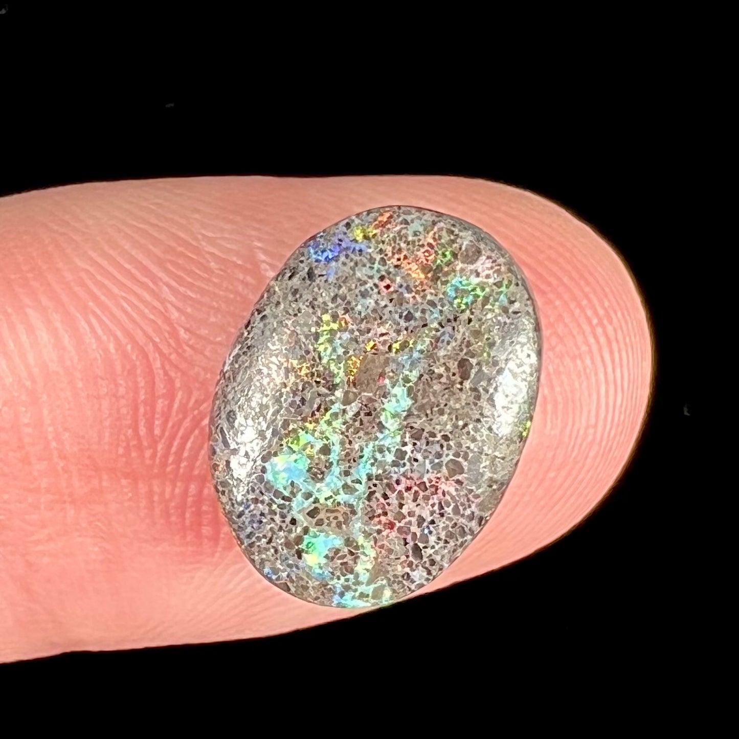 A loose, oval cabochon cut matrix opal stone from Honduras.