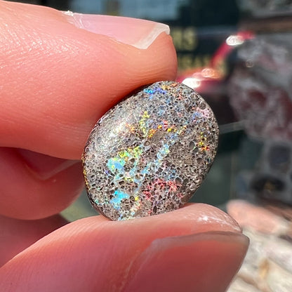 A loose, oval cabochon cut matrix opal stone from Honduras.