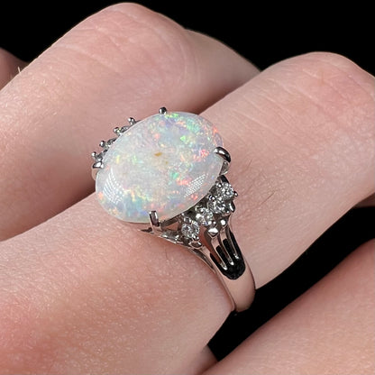 An Australian opal and diamond engagement ring in platinum.  The ring has filigree scrolling.