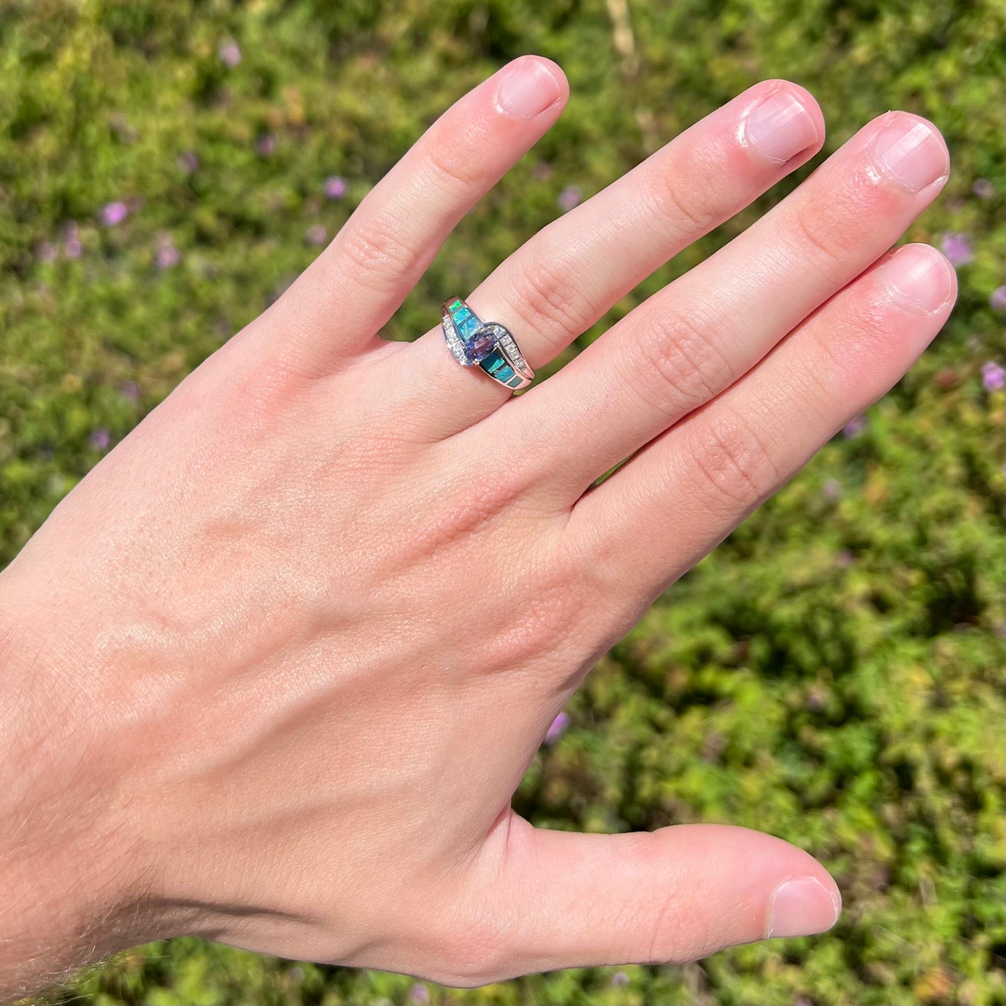 A ladies' white gold tanzanite ring with black opal doublet and diamond accents.