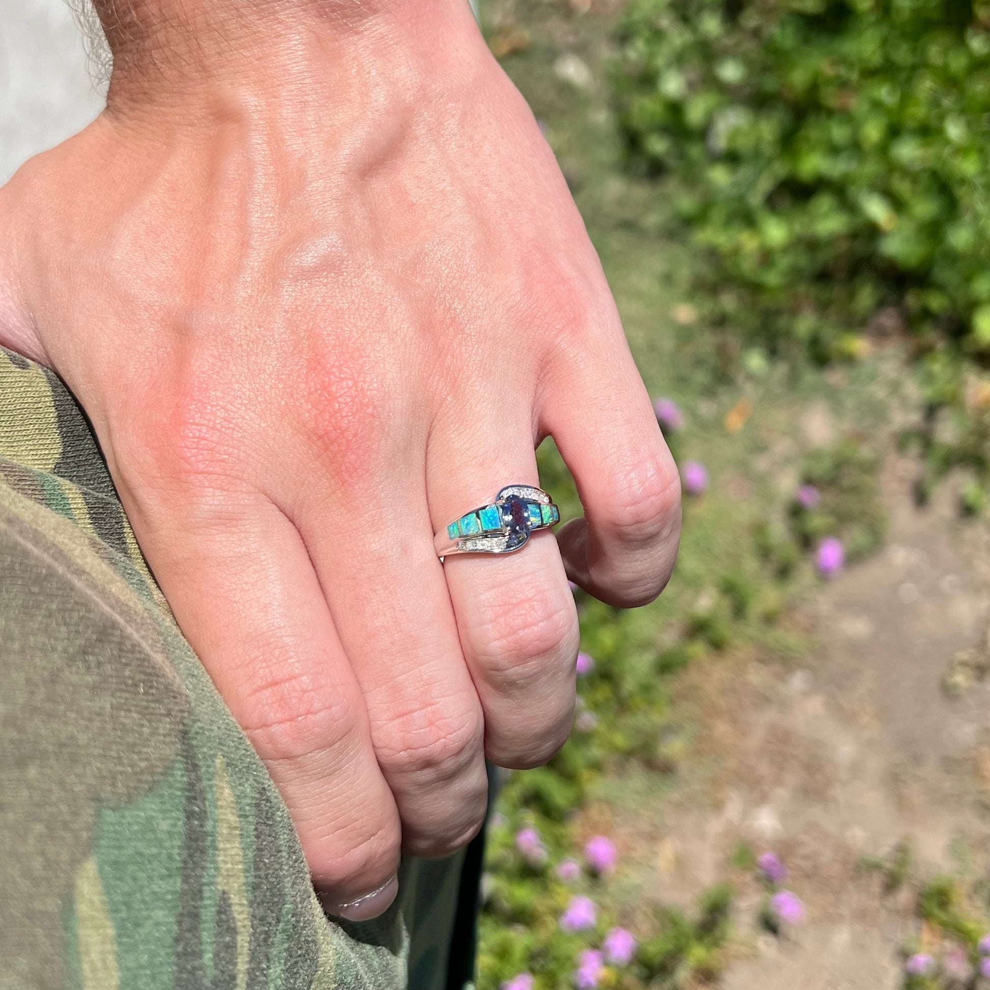 A ladies' white gold tanzanite ring with black opal doublet and diamond accents.