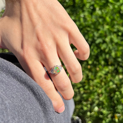 A platinum filigree ring mounted with a high-domed Mexican fire opal and baguette cut diamond accents.