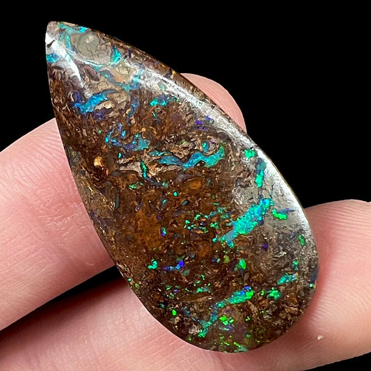 A pear shaped boulder opal stone from Koroit, Australia.  The opal has blue and green flashes.