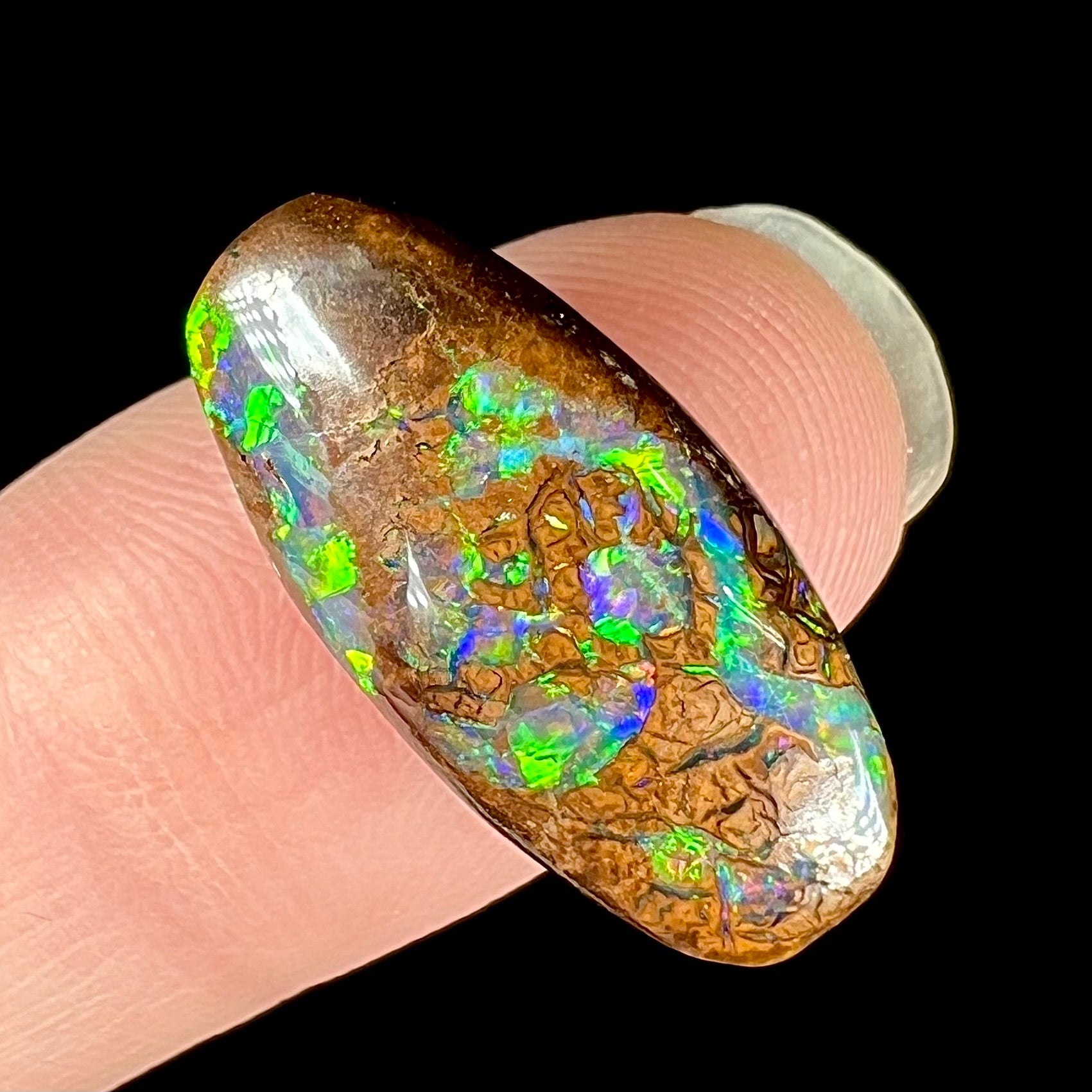 A boulder opal stone with green, blue, and orange fire from Koroit, Australia.