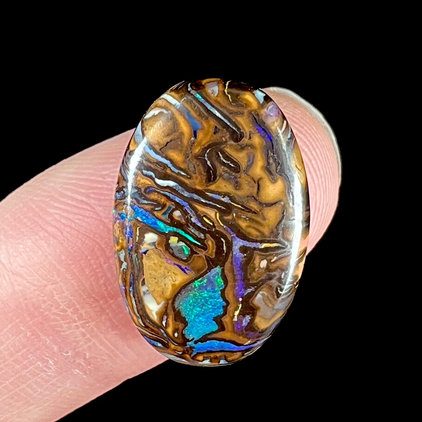 A loose boulder opal from Koroit, Australia.  There is a picture of a face in the stone.