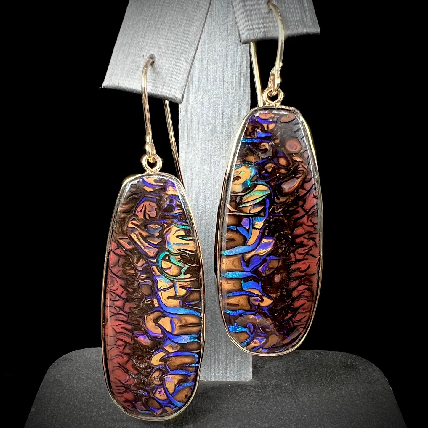 A matched pair of yellow gold patterned boulder opal dangle earrings.  The opals are from Koroit, Australia.