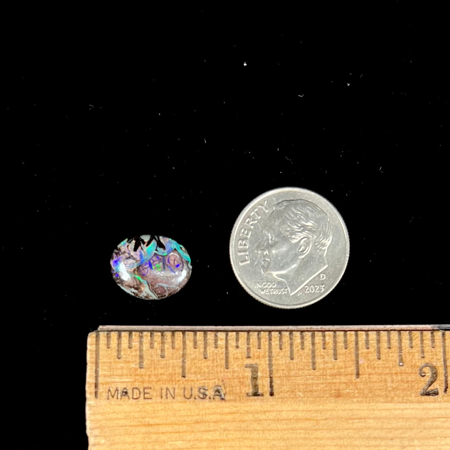 A loose, oval cabochon cut boulder opal stone from Koroit, Australia.  The opal has a bright green flash.