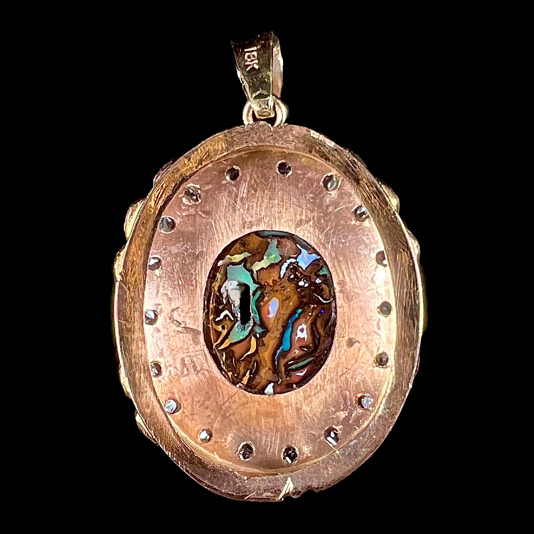 An antique 18 karat yellow gold pendant set with rough diamonds and an oval cut boulder opal from Koroit, Australia.