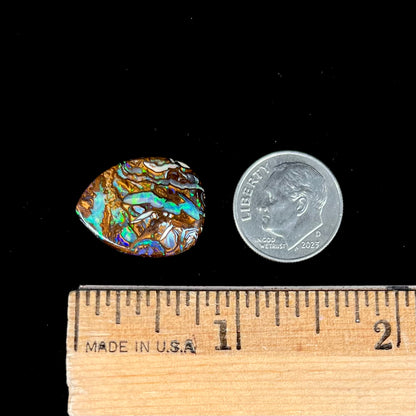 A loose, pear shaped boulder opal stone from Koroit, Australia that has vivd green and blue veins of color.