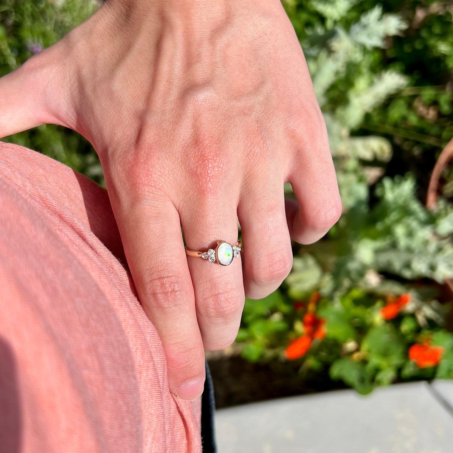 A ladies' yellow gold opal ring.  Three diamonds are set on each side of the opal.  Two rubies are set under the opal.