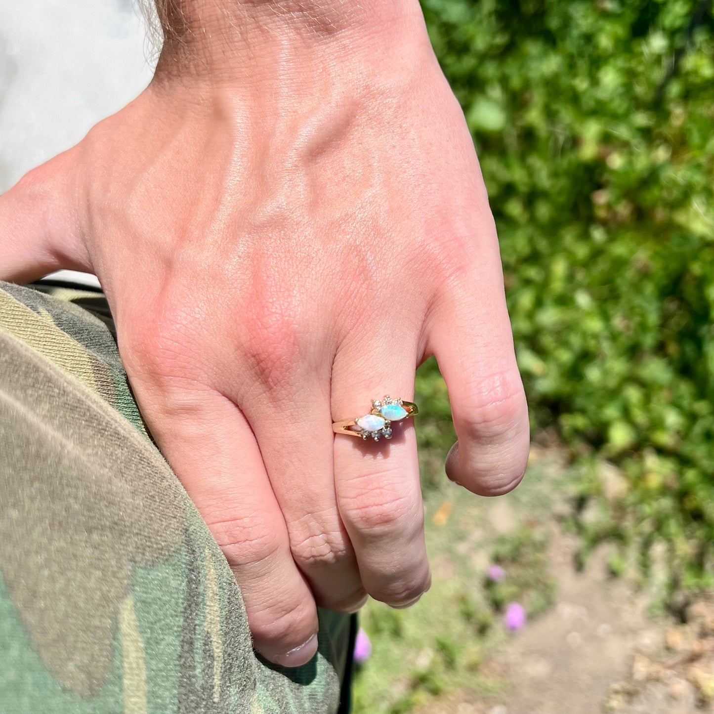 A yellow gold ring mounted with two marquise cut opals and accented with six round diamonds.