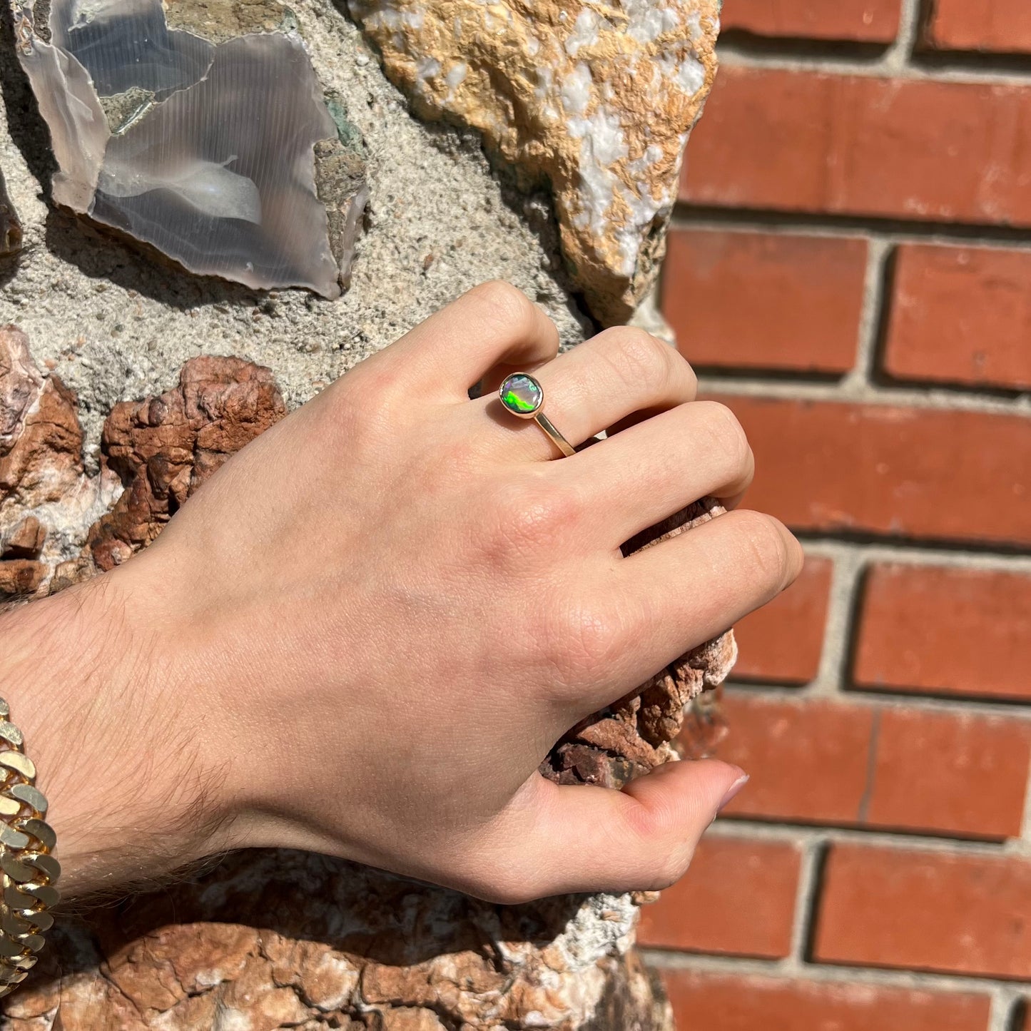 A yellow gold solitaire ring set with a natural Australian cat's eye opal stone.