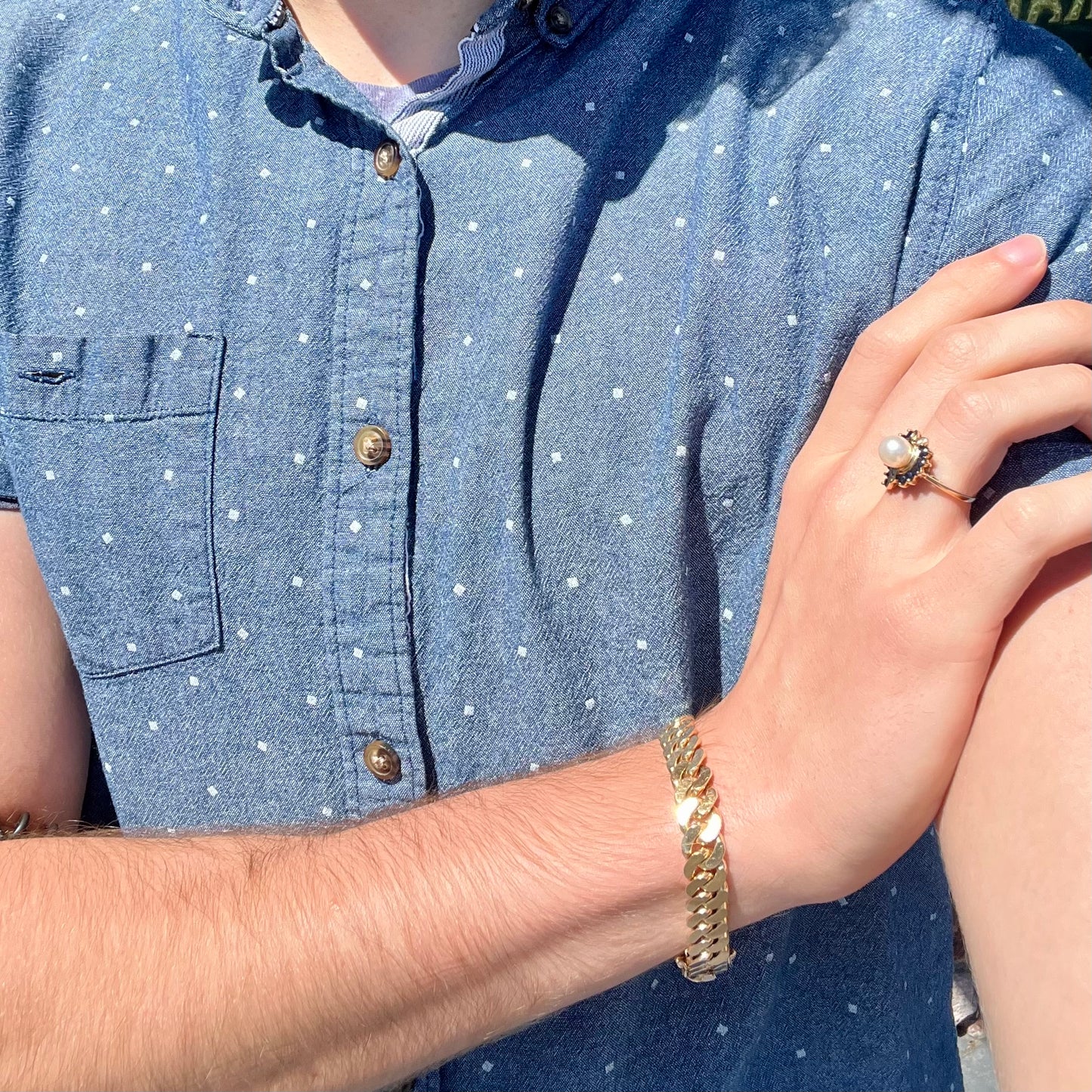 A yellow gold, heart shaped ring set with a freshwater pearl surrounded by blue sapphire and diamond accent stones.