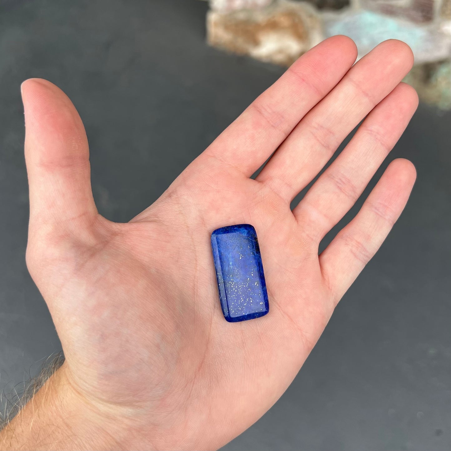 A loose, rectangle cabochon cut AA grade blue lapis lazuli stone.