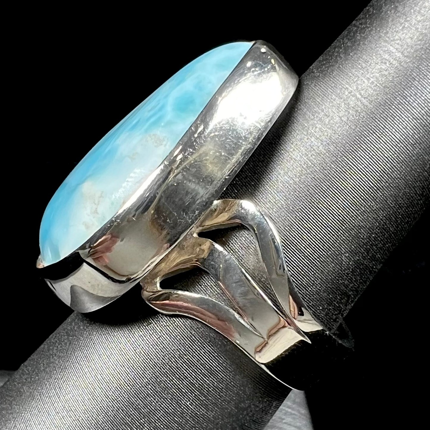 A ladies' large, pear shaped larimar solitaire ring in sterling silver.  The larimar stone measures an inch long.