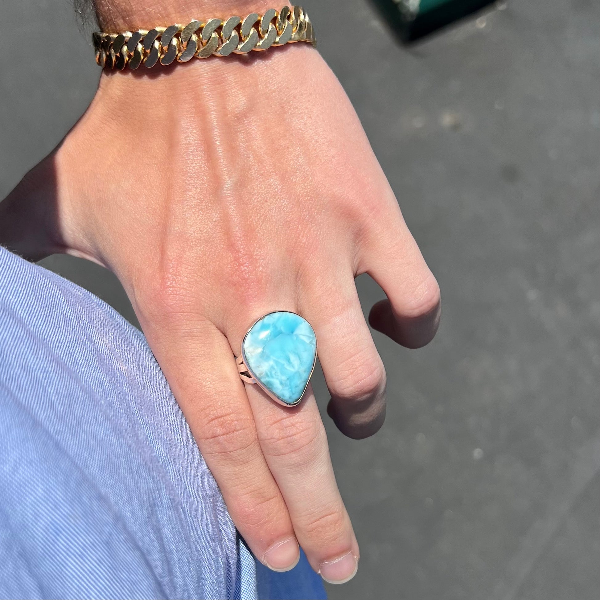 A ladies' large, pear shaped larimar solitaire ring in sterling silver.  The larimar stone measures an inch long.