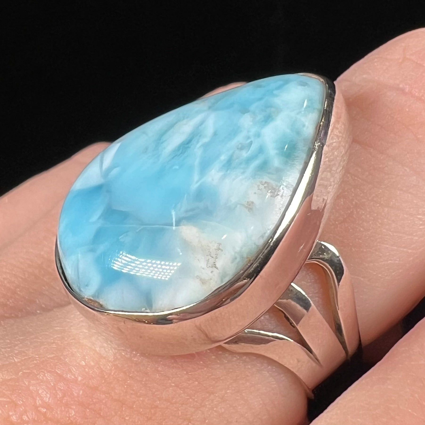 A ladies' large, pear shaped larimar solitaire ring in sterling silver.  The larimar stone measures an inch long.