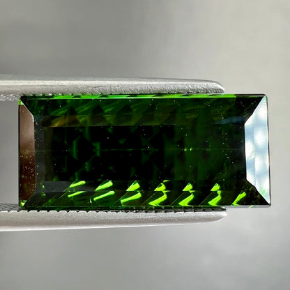 A loose, rectangular laser cut green tourmaline gemstone.