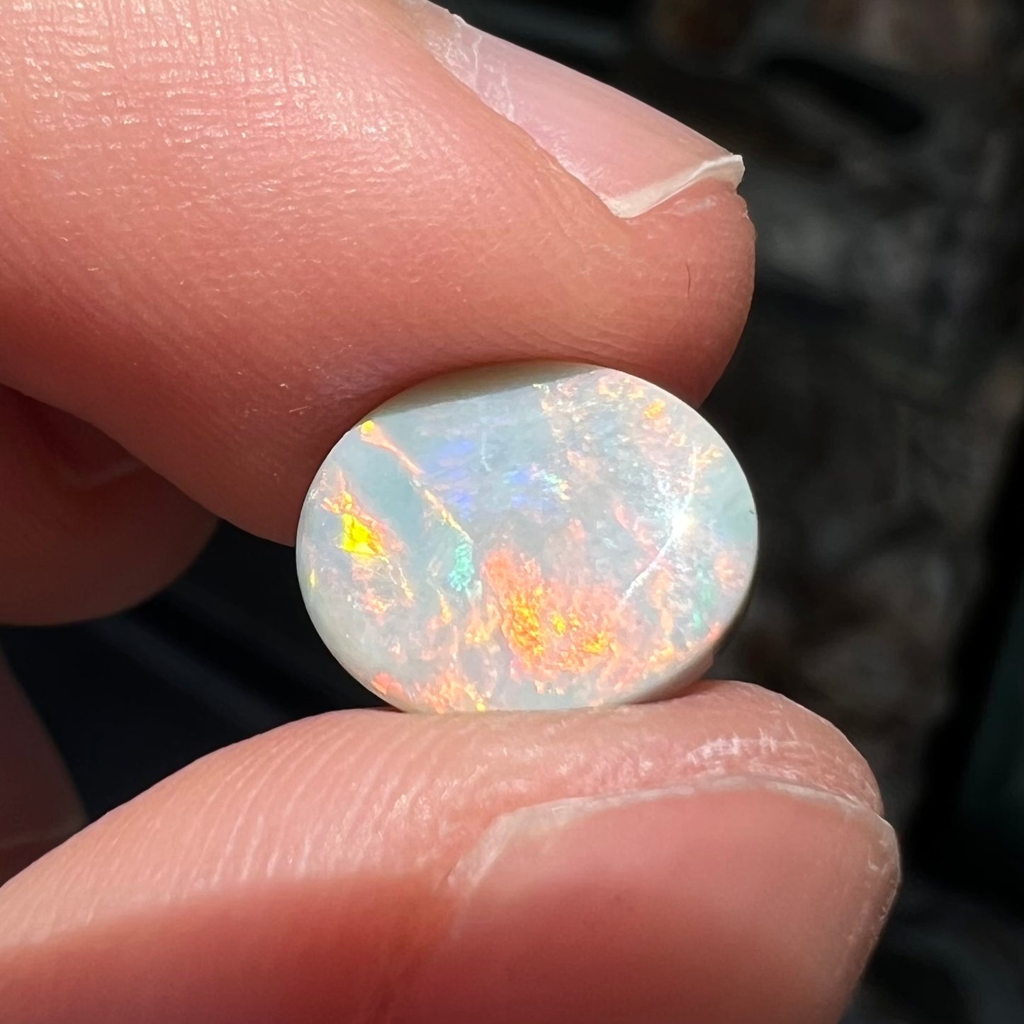 A loose, oval cabochon cut Lightning Ridge light opal stone.