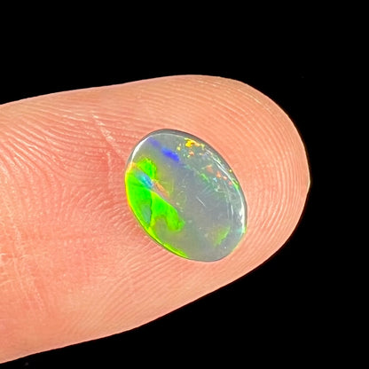 A loose, oval cut black opal from Lighting Ridge, Australia.  The stone is highly directional.