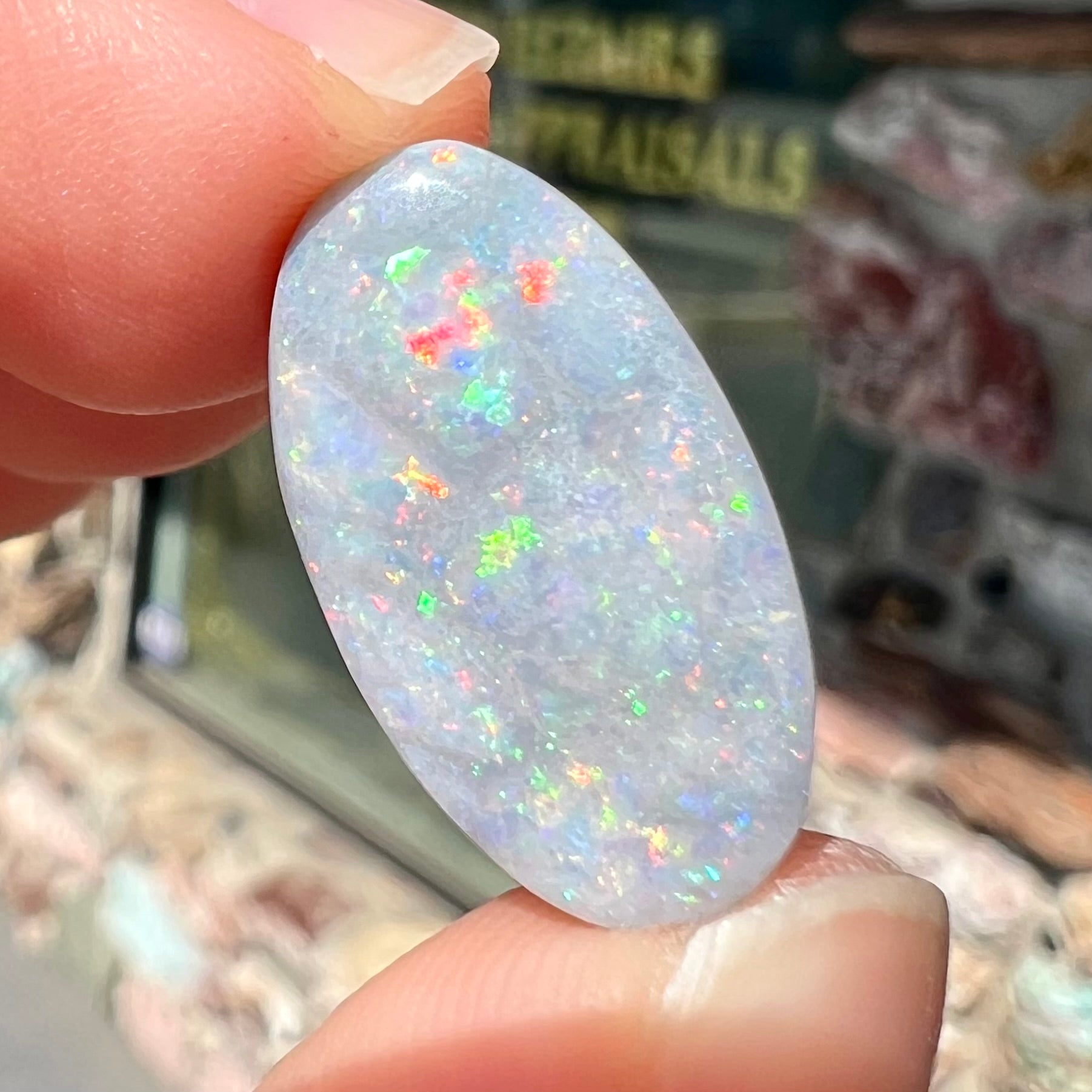 A loose, oval cut semi-black opal stone from Lightning Ridge, Australia.