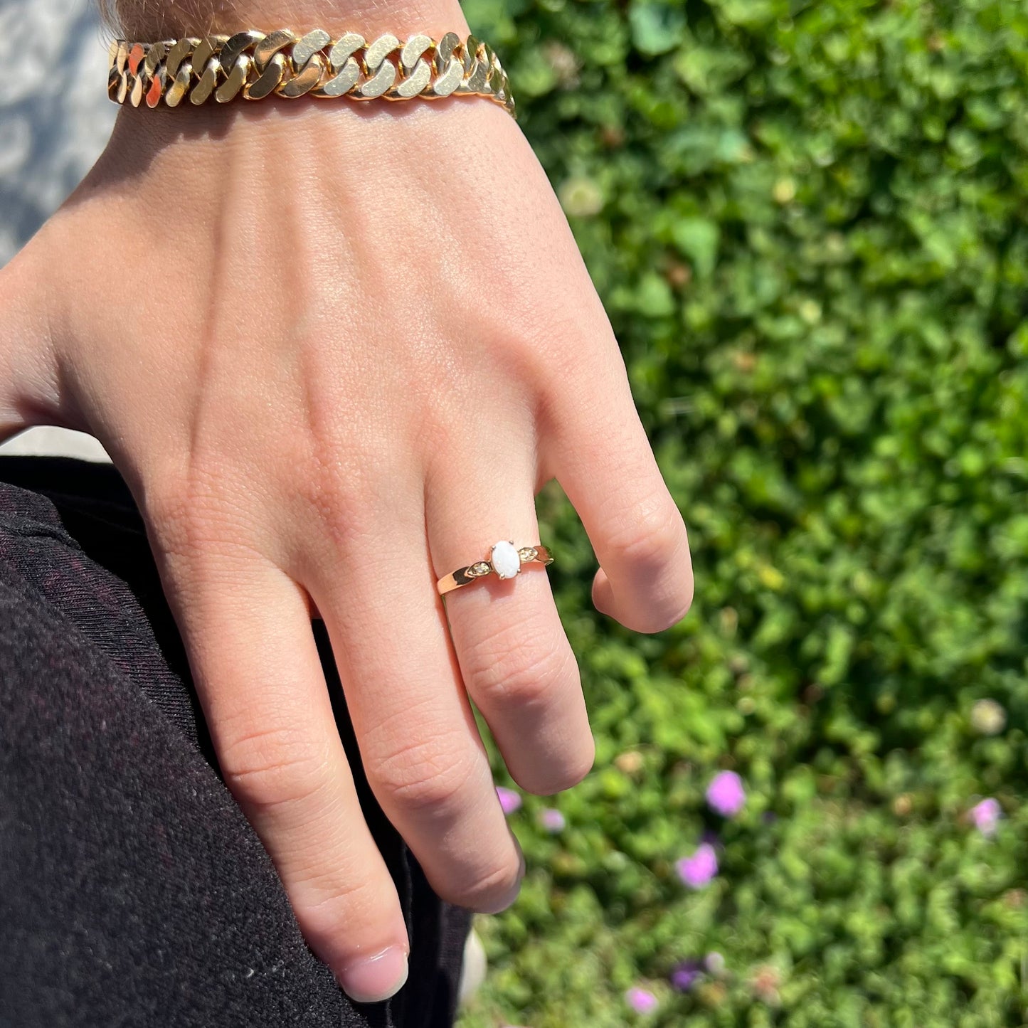 A dainty natural opal and diamond engagement ring in yellow gold.