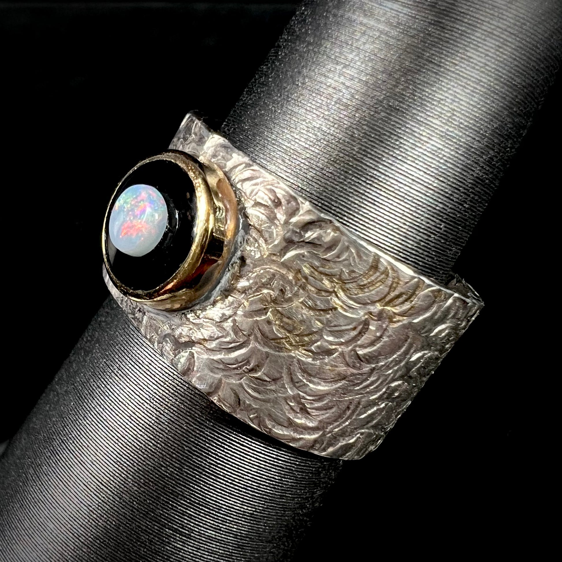 An opal and black onyx inlay ring in a sterling silver cigar-style pinkie ring.